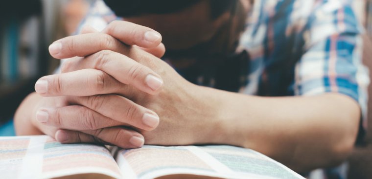 guy praying with a Bible