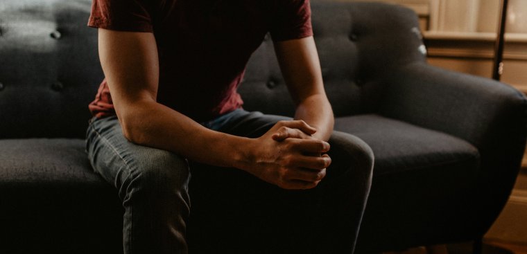 Man sitting on couch presumable ready to be counseled. 